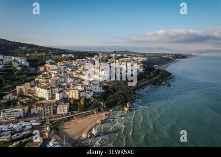 Ein Blick aus der Vogelperspektive fängt das malerische italienische Dorf Sperlonga ein, das zahlreiche weiße Gebäude mit Terrakottadächern entlang eines Grüns beherbergt Stockfoto