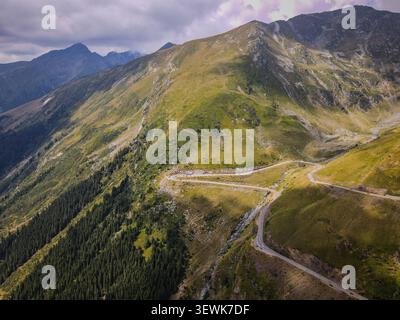 Ein Weitwinkel aus der Luft fängt die Transfagarasan Road mit ihren Haarnadelkurven ein, die in die Seite der Fagaras Mountains gehauen sind. Die Straße schlängelt sich durch gr Stockfoto