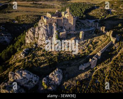 Schloss Loarre, eine romanische Festung, liegt auf einem Felsvorsprung, umgeben von Buschland und Wald im Vorder- und Hintergrund. Diese Drohne Stockfoto