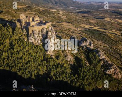 Loarre Castle, eine romanische Festung, befindet sich auf einem Felsvorsprung, umgeben von Kiefern und zerklüftetem Gelände in den Ausläufern der Pyrenäen. Diese Aeria Stockfoto