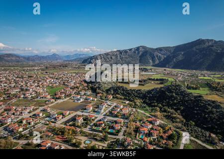 Eine Weitwinkelansicht aus der Luft zeigt Wohngebiete von Fethiye mit Bergen und Tälern im Hintergrund. Dieses Querformat eignet sich für die Darstellung Stockfoto