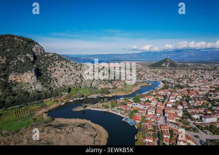 Ein Weitwinkelblick aus der Luft zeigt den Fluss Dalyan, der sich durch Berge schlängelt, und die Stadt Dalyan in der Türkei mit sichtbaren Felsengräbern von Kaunos Anci Stockfoto
