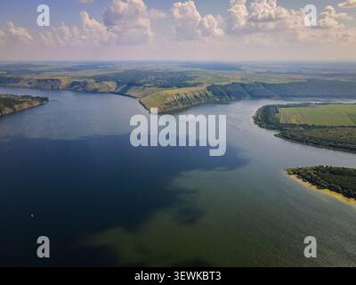 Ein Weitwinkelblick aus der Vogelperspektive fängt den Dniester River ein, der durch ein Tal fließt, das von grünen Hügeln, landwirtschaftlichen Feldern und entfernten Dörfern begrenzt wird Stockfoto