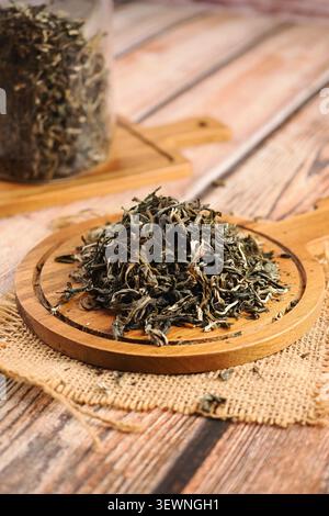 Trockene Teeblätter auf einem Holzbrett in einer Küche Stockfoto