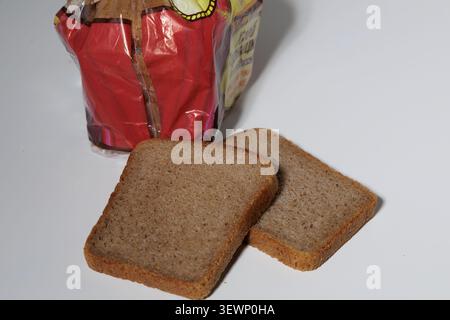 Brotscheiben mit knuspriger Kruste und fester Krume. Auf einer weißen Platte platziert. Stockfoto