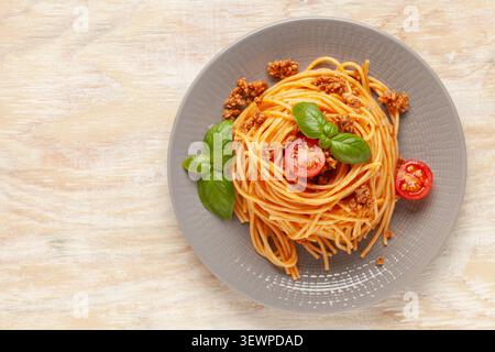 Pasta Spaghetti Bolognese in grauer Platte auf hölzernem Hintergrund. Bolognese-Sauce ist ein klassisches Gericht der italienischen Küche. Beliebte italienische Küche. Draufsicht Stockfoto