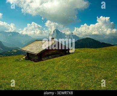Rustikale Berghütte umgeben von Almwiesen in den Dolomiten, Italien Stockfoto