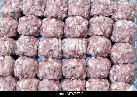 Rohe Fleischbällchen aus Schweinefleisch und Rindfleisch werden ordentlich mit frischen Zutaten zubereitet und für eine köstliche Mahlzeit zubereitet Stockfoto