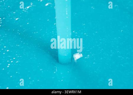 Blaues Flüssigwaschmittel aus der Nähe gießen, abstrakter Hintergrund. Stockfoto