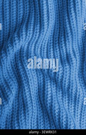 Nahaufnahme, Makro aus zerknittertem blauem Strickstoff. Tuch mit sichtbaren Falten, Falten und weichen Wellen. Weiches Wollmaterial mit detaillierten s Stockfoto