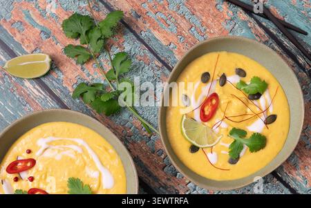 Detaillierte Überkopfkomposition mit cremiger Kürbissuppe und frischen Garnituren Stockfoto