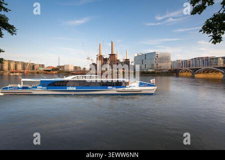 Ein MBNA Thames Clipper durchquert die Londoner Themse, vorbei am berühmten Battersea Power Station und der Grosvenor Railway Bridge. Stockfoto