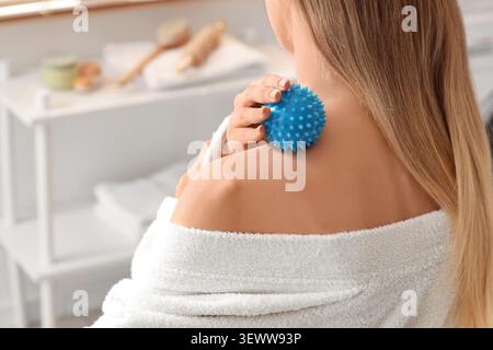 Frau mit blauem, stacheligem Massageball auf der Schulter Stockfoto