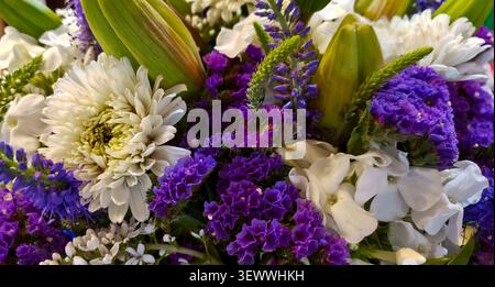 Farbenfroher Blumenstrauß mit weißen Chrysanthemen, lila Statice und Lilienknospen aus nächster Nähe Stockfoto