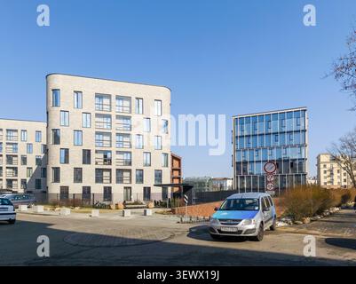 Minsk Weißrussland März 30 2026 Moderne Luxuswohnungen stehen in der Nähe eines geparkten Autos in einem Wohngebiet. Moderne Architektur bildet gehobene Häuser Stockfoto