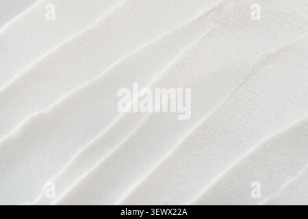 Weiße Kosmetikcreme für abstrakte Pinselstriche und glatte Wellen auf der Oberfläche Stockfoto
