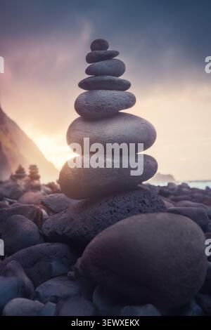 Zen-Steinpyramide an einem Kieselstrand bei Sonnenuntergang auf Madeira Stockfoto