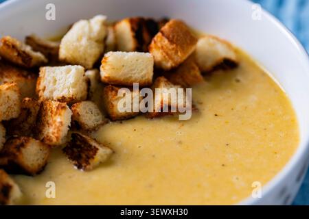 Hausgemachte cremige Linsensuppe mit knusprigen Croutons in einer weißen Schüssel. Gesunde vegetarische Komfortgerichte mit einer glatten Textur, perfekt zum Mittagessen oder zum d Stockfoto