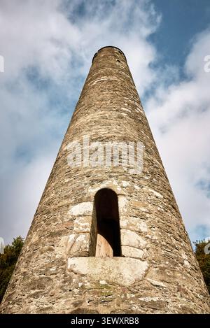 Niedrigwinklige Ansicht des mittelalterlichen Rundturms in Glendalough, Irland Stockfoto