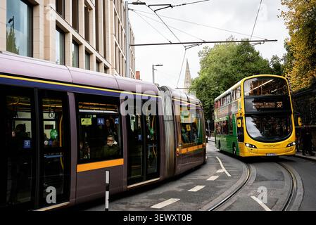 Luas-Straßenbahn und Doppeldecker-Bus auf der Nassau Street in Dublin, Irland Stockfoto