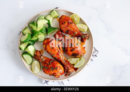 Würzige gebackene Hähnchenkeulen mit Gurkensalat Stockfoto