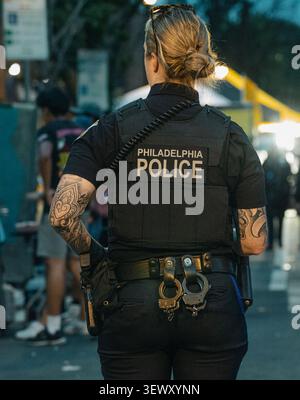 Tätowierte Polizistin auf Patrouille nachts Stockfoto