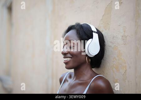 Glückliche junge Frau Musikhören mit Kopfhörer Stockfoto