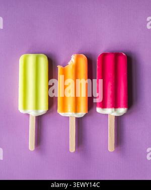 Bunte Eis-Pops, die mit einem Gebissen aufgereiht sind Stockfoto