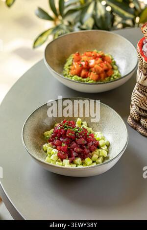 Thunfisch- und Lachs-Poke-Schüsseln mit Tiki-Cocktail Stockfoto