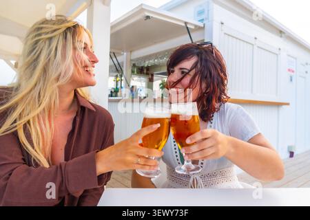 Freunde, die Bier trinken, genießen Sommerurlaub in der Strandbar Stockfoto