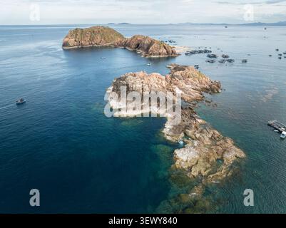 Drohnenblick auf felsige Inselchen und das ruhige blaue Meer bei EO Gio, Quy Nhon, Gia Lai, vietnamesischer Küste. Stockfoto