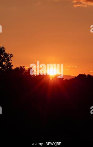 Die untergehende Sonne sinkt hinter dem Berg. Stockfoto