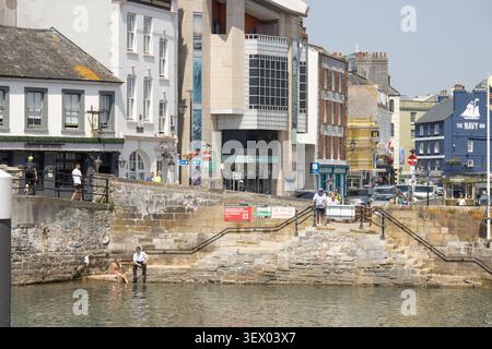 Blick auf die Mayflower Steps Slipway und Steinmauern mit dem Admiral MacBride Pub und Mayflower Museum im Hintergrund, Plymouth Barbican Stockfoto