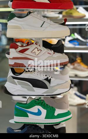 Turnschuhe verschiedener Marken in den Regalen des Stores – Nike, Air Jordan, Puma, New Balance, Lacoste. Minsk, Weißrussland - 30. März 2026 Stockfoto