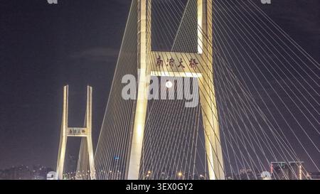 Blick aus der Vogelperspektive auf die beleuchtete Nanpu-Brücke bei Nacht mit ihren unverwechselbaren H-förmigen Türmen und der Struktur, die den Huangpu-Fluss in Sha überspannt Stockfoto