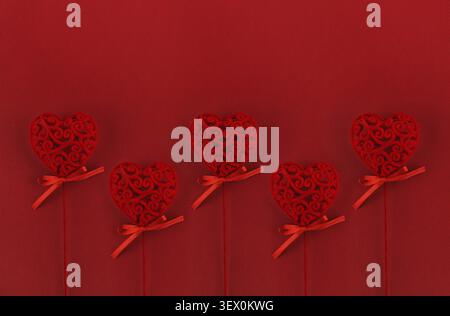 Rote Samtherzen auf strukturiertem Papierhintergrund zum Valentinstag Stockfoto