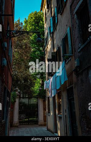 Schmale Wohnstraße mit hängender Wäsche im historischen Venedig, Italien Stockfoto