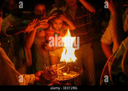 Hinduistische Priester führen die Abendzeremonie Ganga Aarti in Har Ki Pauri, Haridwar, Uttarakhand, Indien, durch, während sich Gläubige in der Dämmerung am Ufer des Ganges versammeln. Stockfoto