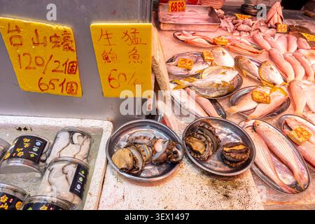 Auswahl an frischen Meeresfrüchten, lebenden Abalone, Austern und verschiedenen Fischarten auf Eis zum Verkauf, Preise in Hongkong Dollars, Bowrington Market Stockfoto