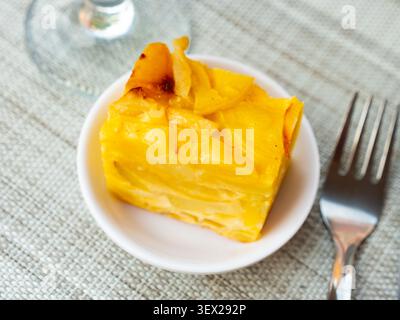 Auf einem kleinen Teller befindet sich ein Stück üppiges, hoch gebackenes Kartoffelomelett Stockfoto