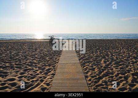 Holzsteg führt zum Mittelmeer am Sanddünen-Strand von Piscinas bei Sonnenuntergang in Sardinien, Italien Stockfoto