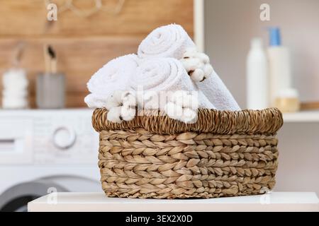 Weiße Handtücher in gewebtem Korb mit Baumwollblumen Stockfoto