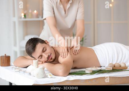 Junger Mann, der sich im Spa-Salon massiert Stockfoto