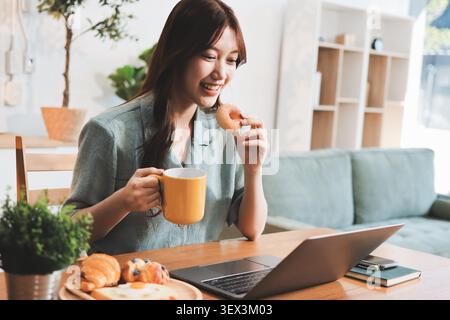 Glück Unternehmer schönes Geschäft asiatische junge Frau tragen lässig Handy zum Einkaufen online genießen Sie mit sozialen Medien und Laptop zu Hause Stockfoto
