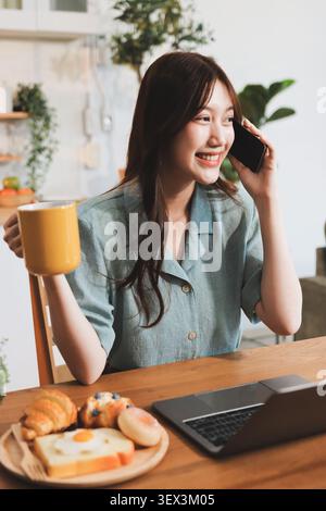 Glück Unternehmer schönes Geschäft asiatische junge Frau tragen lässig Handy zum Einkaufen online genießen Sie mit sozialen Medien und Laptop zu Hause Stockfoto