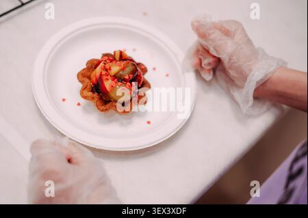 Frische Obsttarte mit Pfirsichen und Beeren auf weißem Teller, zubereitet vom Koch Stockfoto