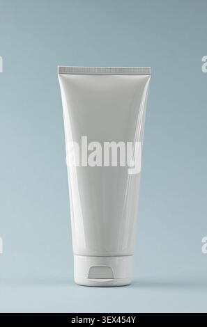 Weiße Kosmetikröhre auf blauem Hintergrund für Hautpflegeprodukt Mockup und Design Stockfoto