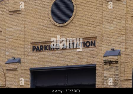 Kiew, Ukraine - 21. März 2026: Schwarzer Text auf einer gelben Ziegelwand beschriftet eine Parkstation und hebt die industrielle städtische Architektur hervor Stockfoto