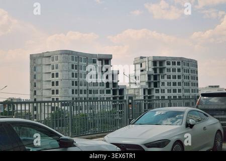 Moderne Apartmenthäuser mit geparkten Autos in einer Wohngegend. Perfekt für Immobilien, städtisches Wohnen, Wohnen und städtische Infrastruktur Stockfoto