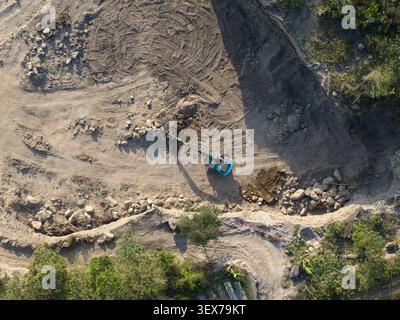 Luftaufnahme eines Sand- und Steinbruchs mit einem Bagger, der am Boden in Manisrenggo, Zentral-Java, Indonesien arbeitet. Stockfoto